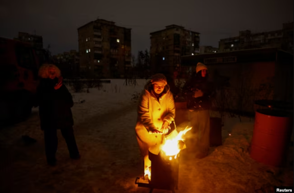 Жителі Києва гріються біля вогнища у дворі під час блекауту, січень 2026 року